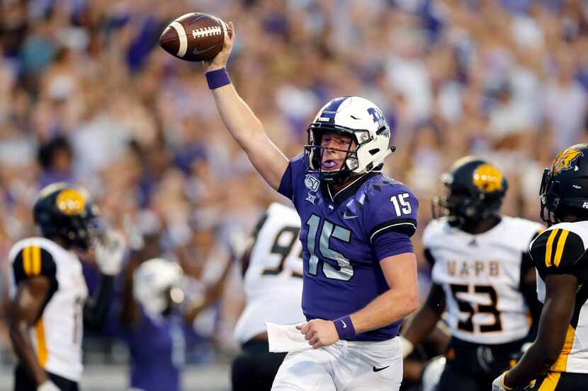 TCU Horned Frogs quarterback Max Duggan (15) ducked under a defender and ran in a first...