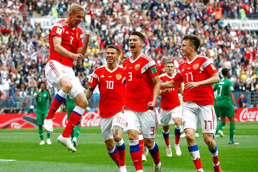 El ruso Yuri Gazinsky (izquierda) celebra con sus compañeros tras anotar el primer gol de...