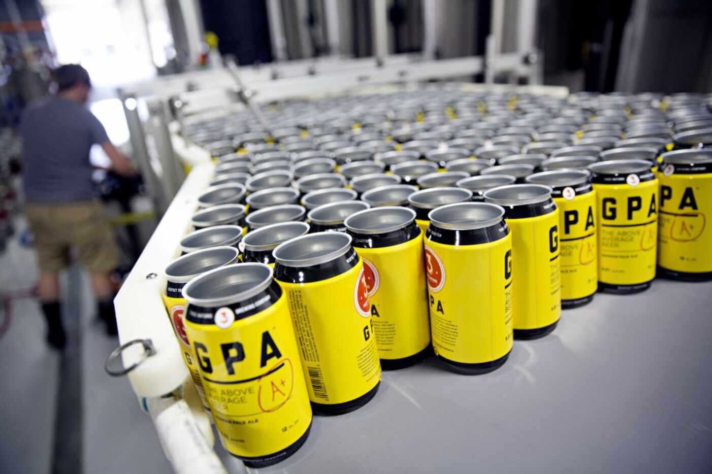 Empty cans are lined on a machine used to can beer at 3 Nations Brewing Friday, October 16,...