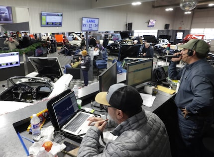 Auctioneers take bids during an auction at Manheim in Dallas, Texas, December 18, 2024.