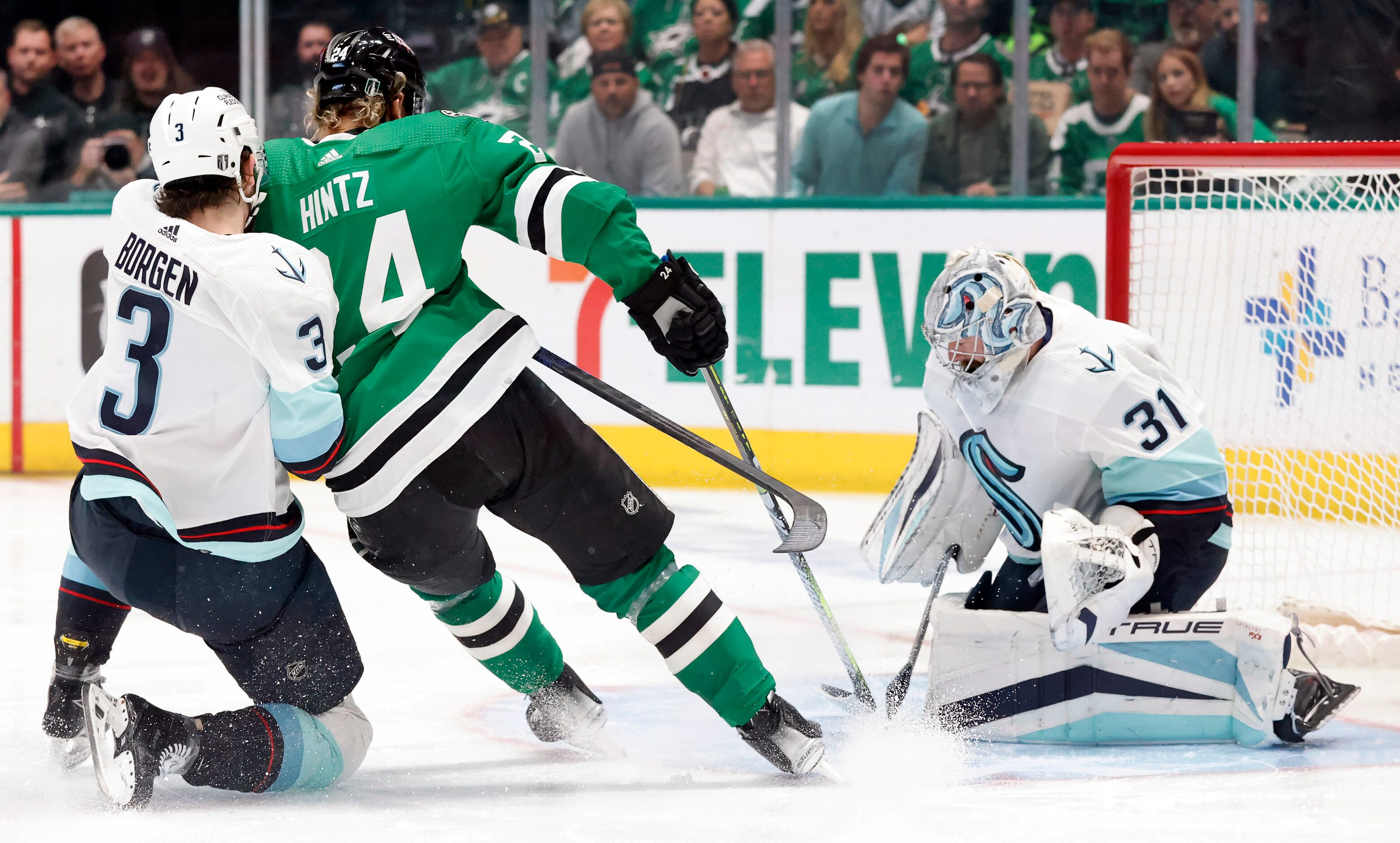 Dallas Stars center Roope Hintz (24) attempts to push the puck past Seattle Kraken...