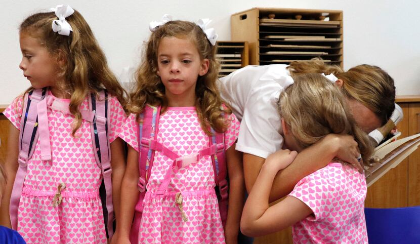 From left: Six-year-old triplets Emma, Chloe and Rosie Gilmore got hugs from their mother,...