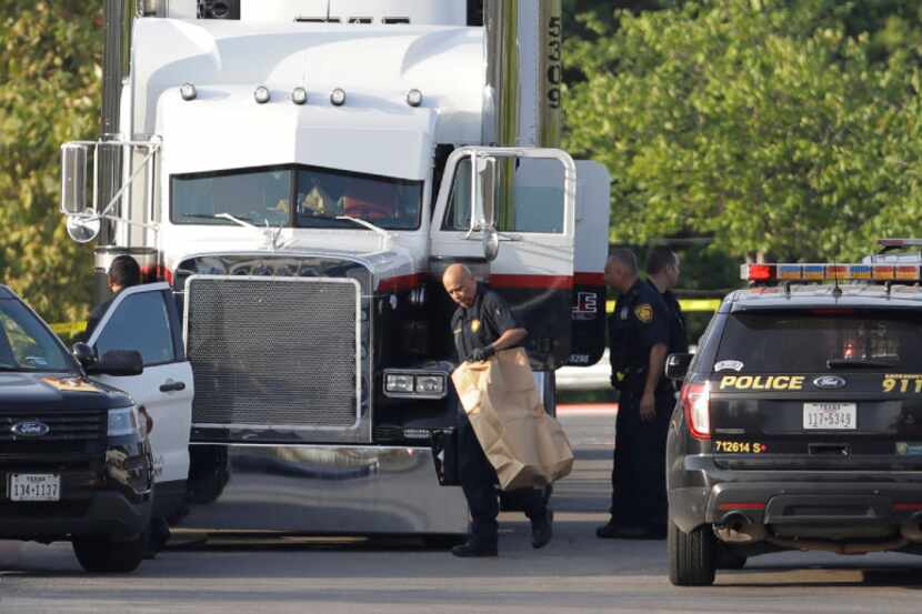 San Antonio police officers investigated the scene Sunday where dozens of immigrants were...