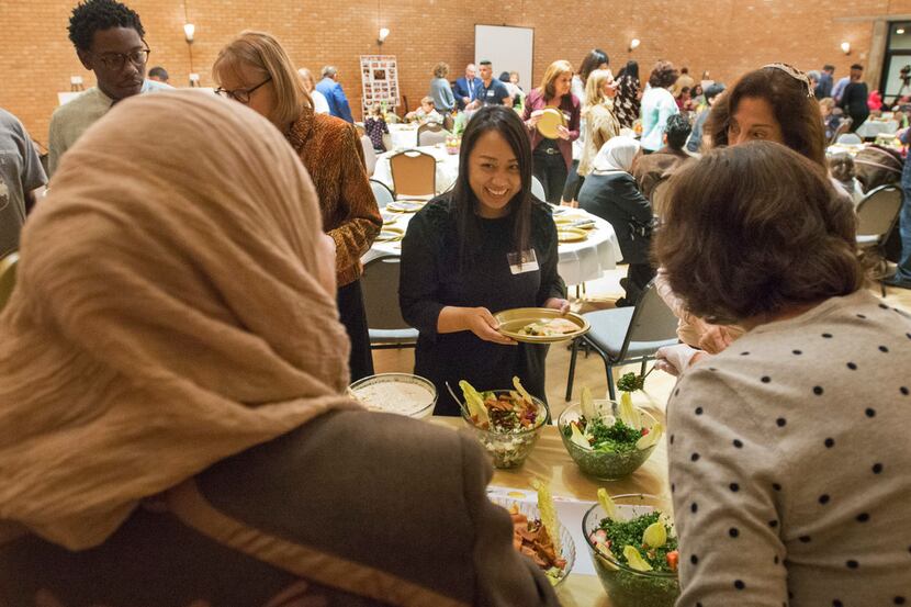 Mariam Alshiblaq, a Syrian refugee, left, laughs with a guest at the Leah's Kitchen annual...