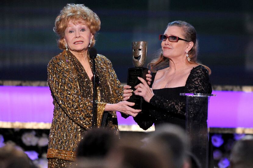 FILE- In this Jan. 25, 2015, file photo, Carrie Fisher, right, presents her mother Debbie...