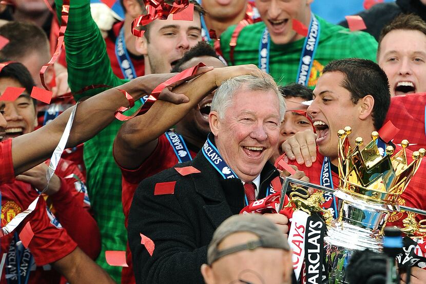 Manchester United players celebrate with their manager Alex Ferguson (C) as he holds the...