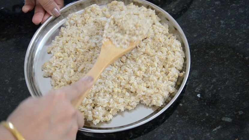 The Coconut Burfi mixture is spread into a pan.