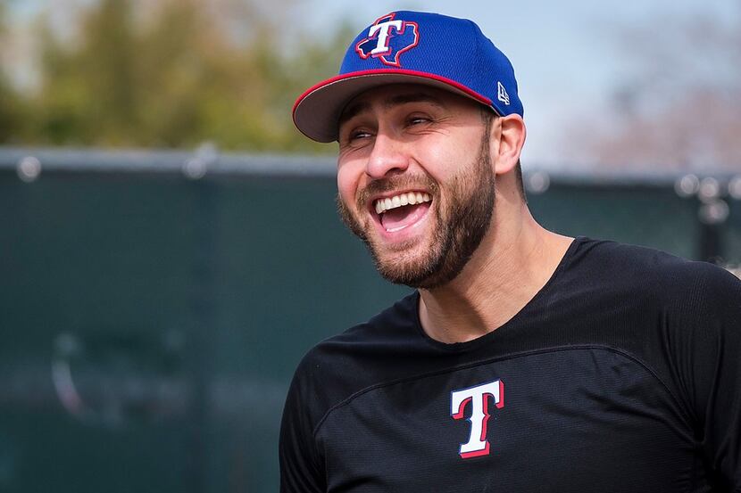 Texas Rangers outfielder Joey Gallo laughs with teammates as they participate in a base...