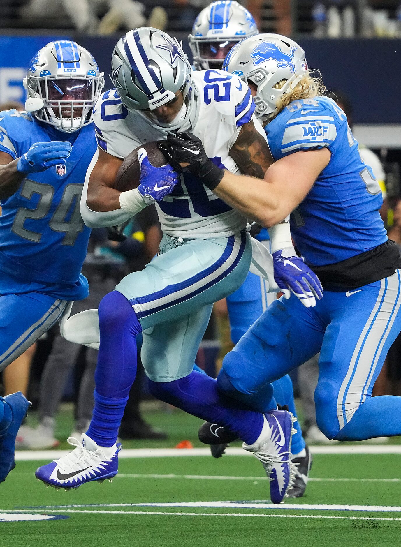 Dallas Cowboys running back Tony Pollard (20) is brought down by Detroit Lions linebacker...