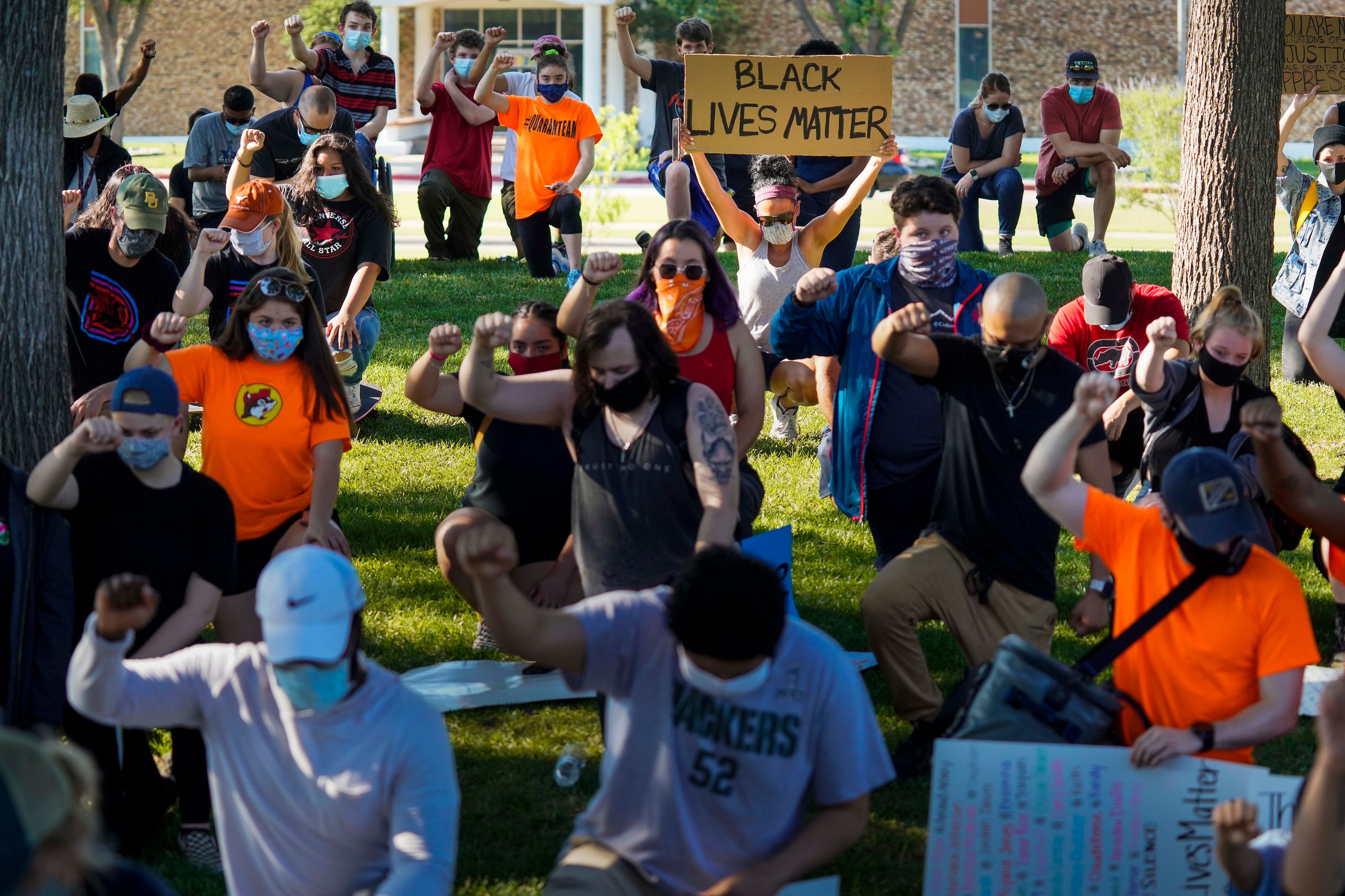 Demonstrators take a knee for 8 minutes and 46 seconds during a protest organized by Berkner...