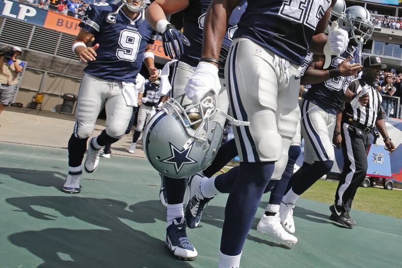 Dallas Cowboys free safety Barry Church (42) and quarterback Tony Romo (9) take the field...