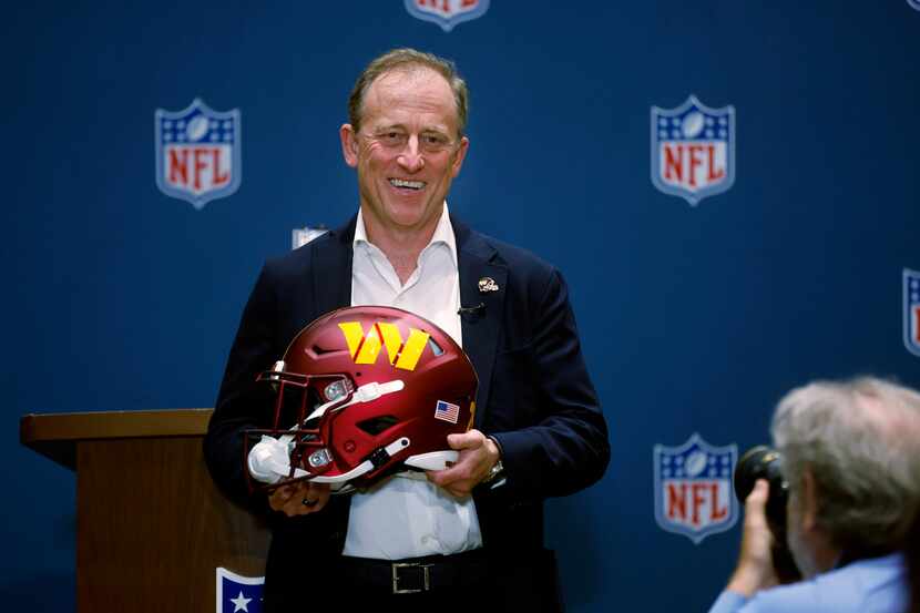 Josh Harris, leader of a group buying the Washington Commanders, poses with a team helmet...