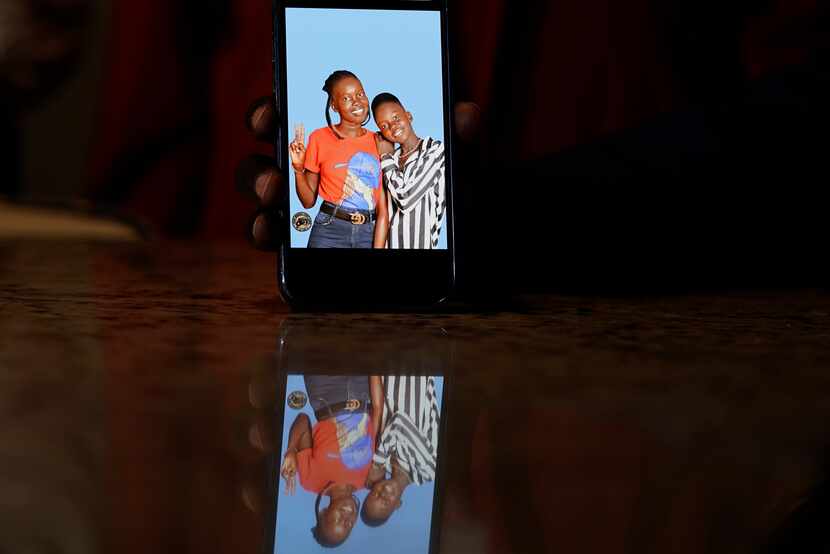 Jacob Mabil shows a cell phone photo of hie nieces Nyanluak Deng (left) and Anyier Deng. LM...