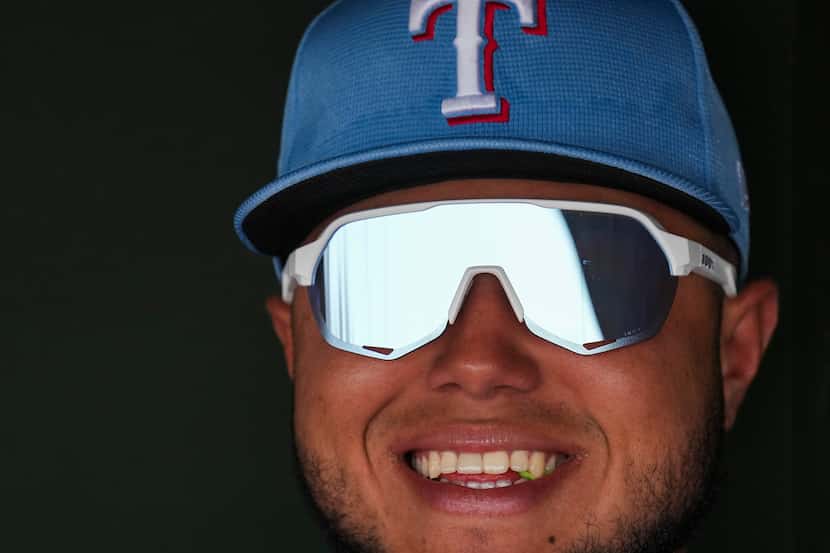 Texas Rangers infielder Abimelec Ortiz looks out from the dugout before a spring training...