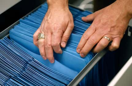 Tarrant County Justice of the Peace Precinct 5 Sergio L. De Leon thumbs through some of the...