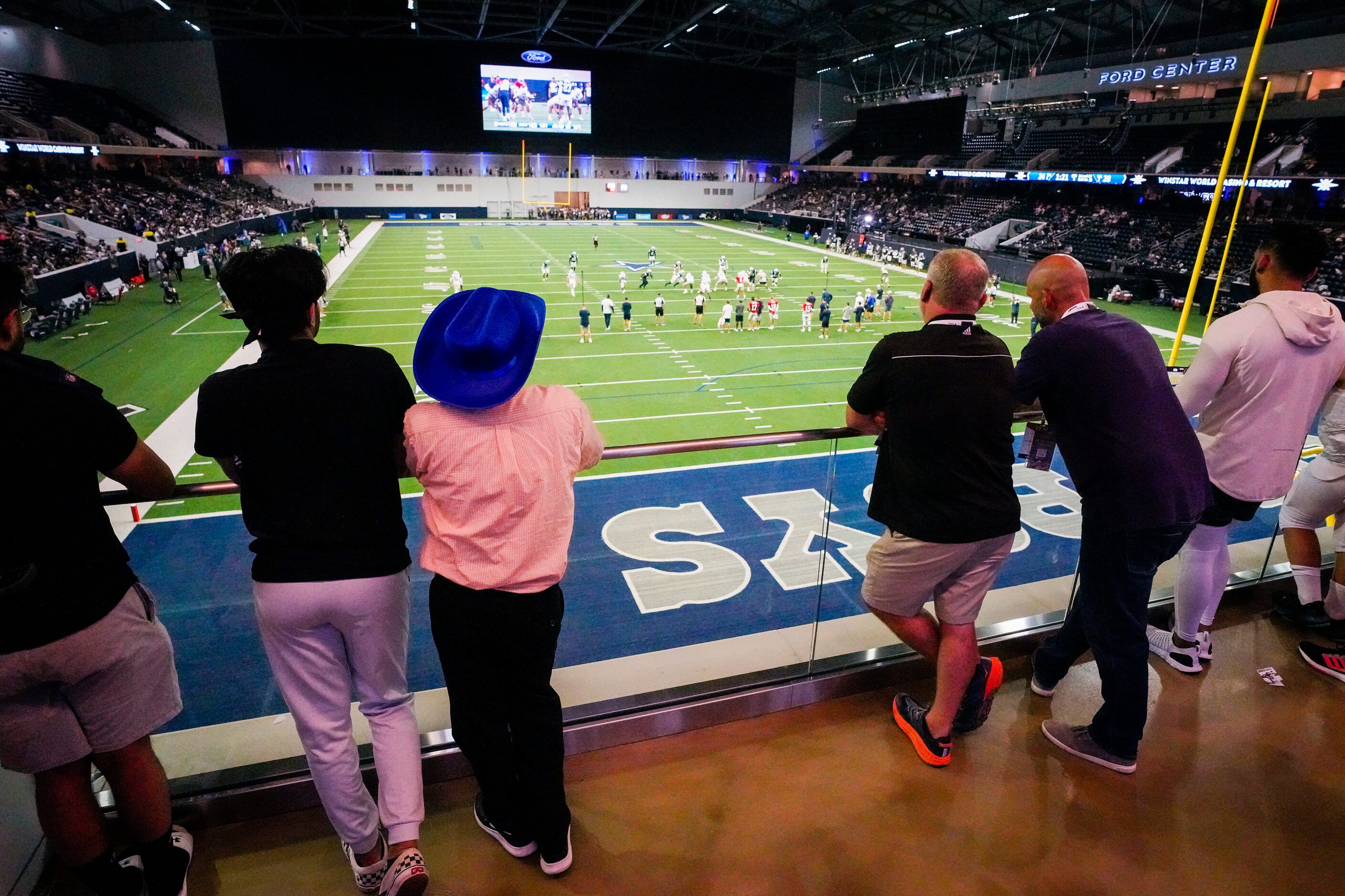 Fans watch a Dallas Cowboys open training camp practice at The Star on Tuesday, Aug. 23,...