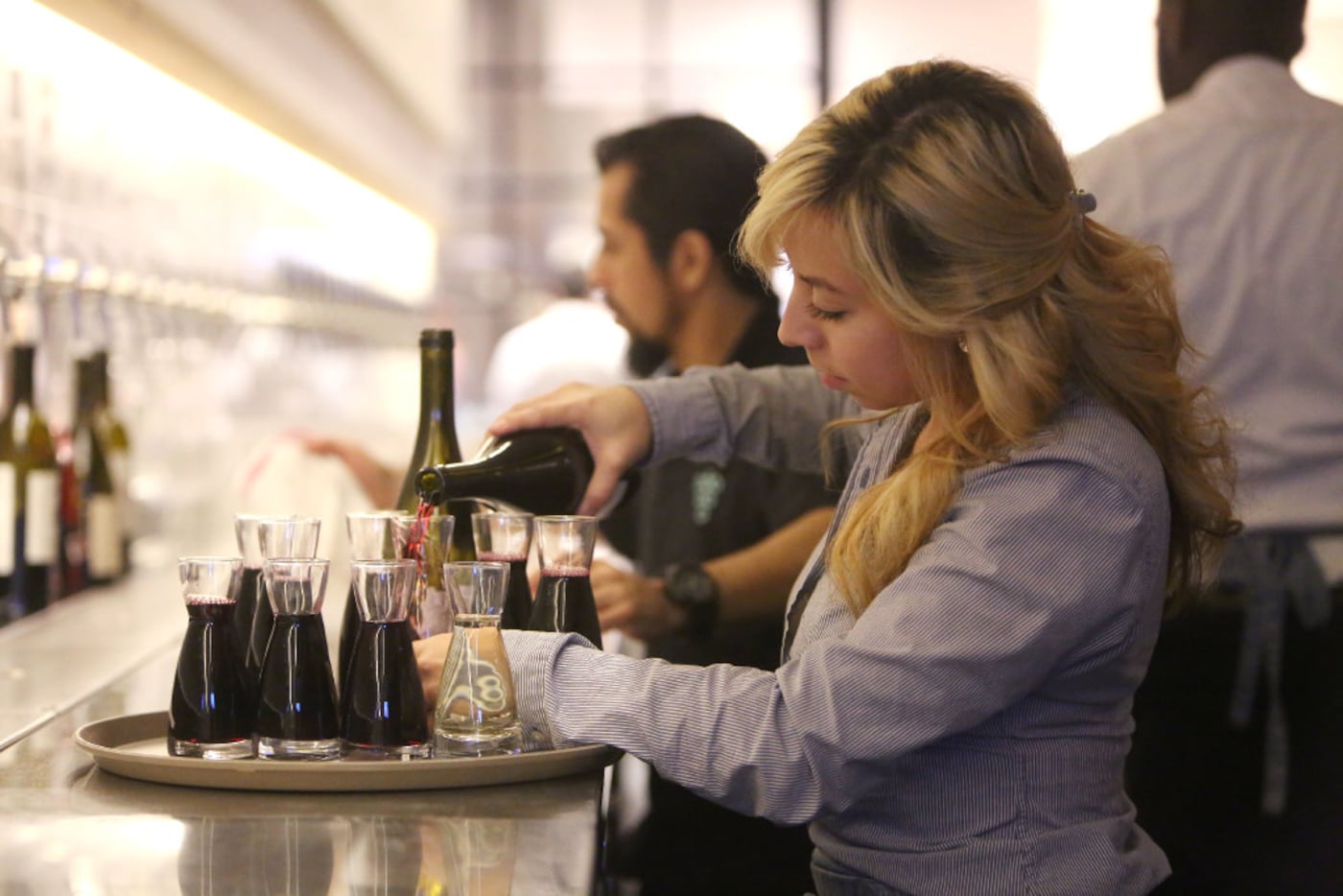 Bartender Christina Valencia pours wine at Sixty Vines, a new wine-centric restaurant in...