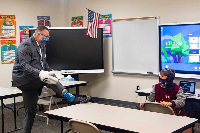 Superintendent Dr. Michael Goddard (left) shows off his playful socks to sixth-grade student...