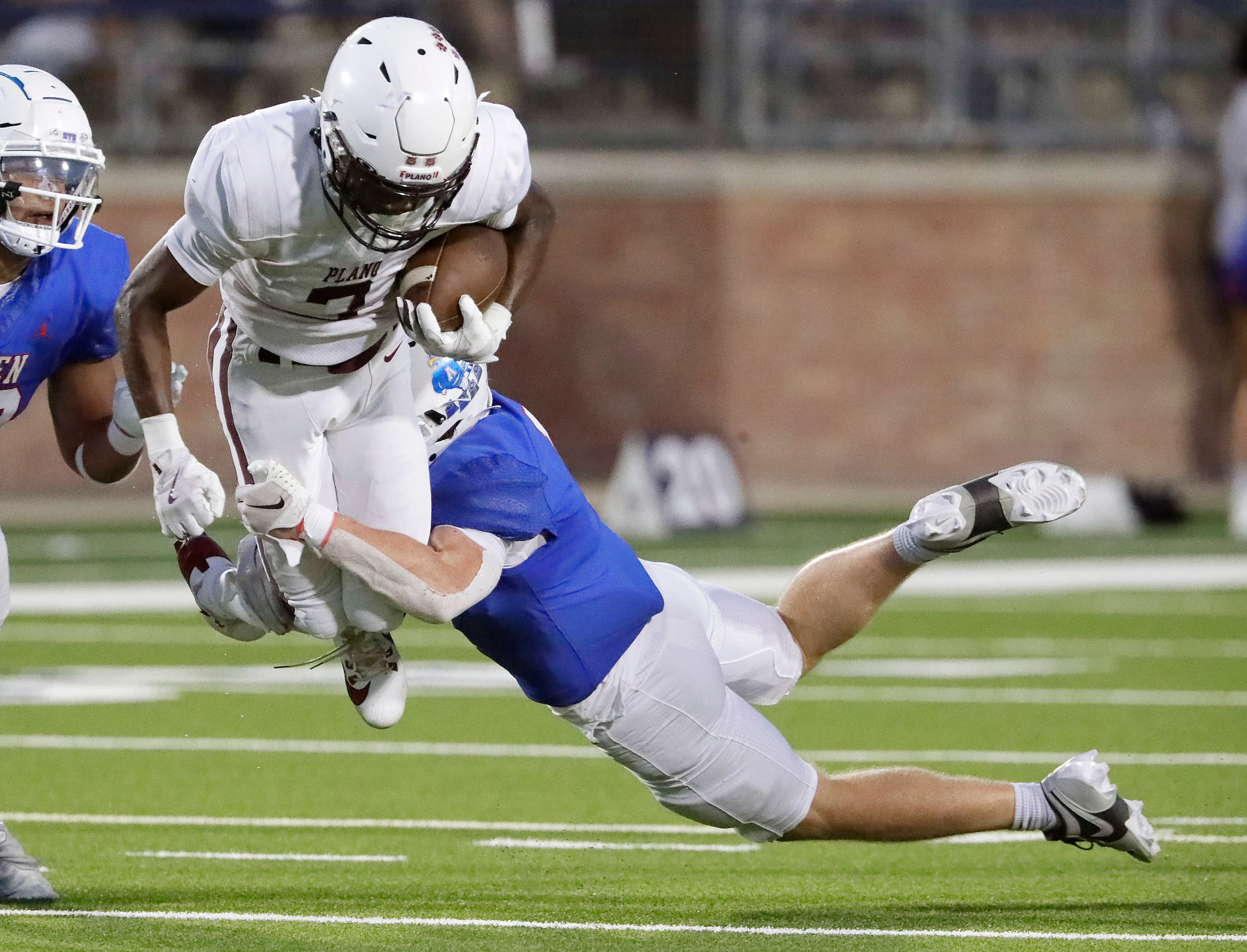 Allen High School linebacker Mitchell Neu (1) makes a flying tackle on Plano High School...