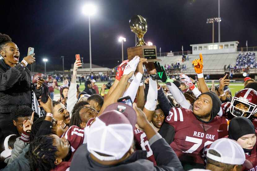 Red Oak players raise the UIL District 4-5A Division I trophy after winning a game against...