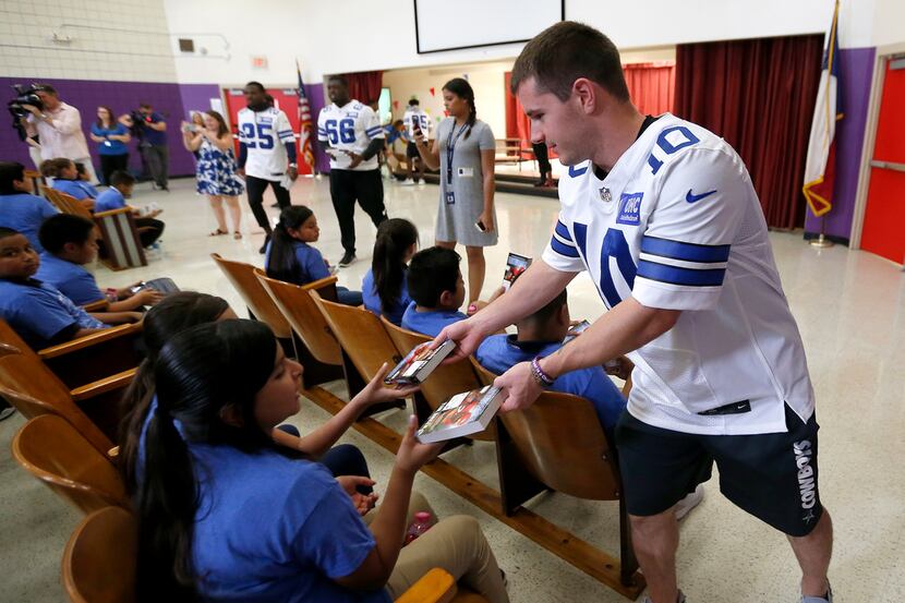 Dallas Cowboys rookie Ryan Switzer (10) hands books to 5th graders during an NFL PLAY 60 /...
