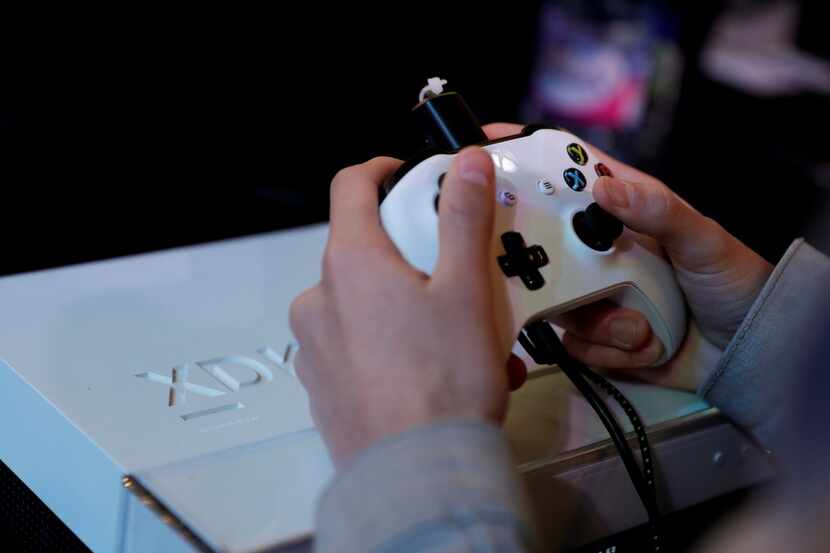 In this file photo taken on Nov. 5, 2017 a gamer plays video games with a Xbox console...