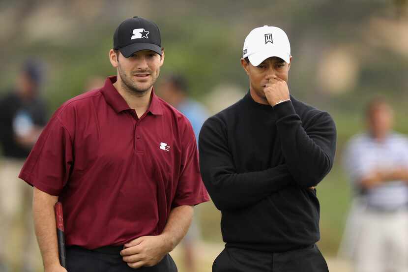 Dallas Cowboys quarterback Tony Romo talks with Tiger Woods on the ninth green after putting...