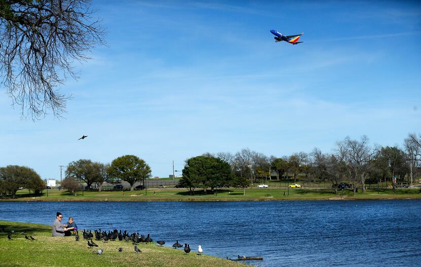 A Southwest Airlines jet takes off from Love Field as Roxie Murillo (left) of Dallas and...