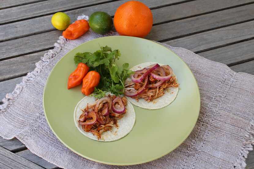 Cochinita pibil is traditionally served wrapped in warm corn tortillas with pickled onions. 