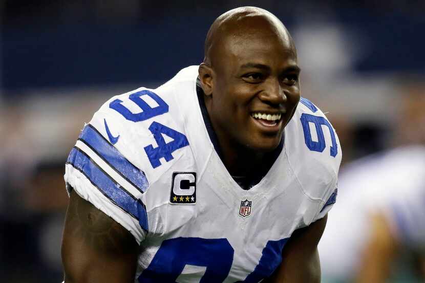 Dallas Cowboys defensive end DeMarcus Ware talks with teammates while stretching during...