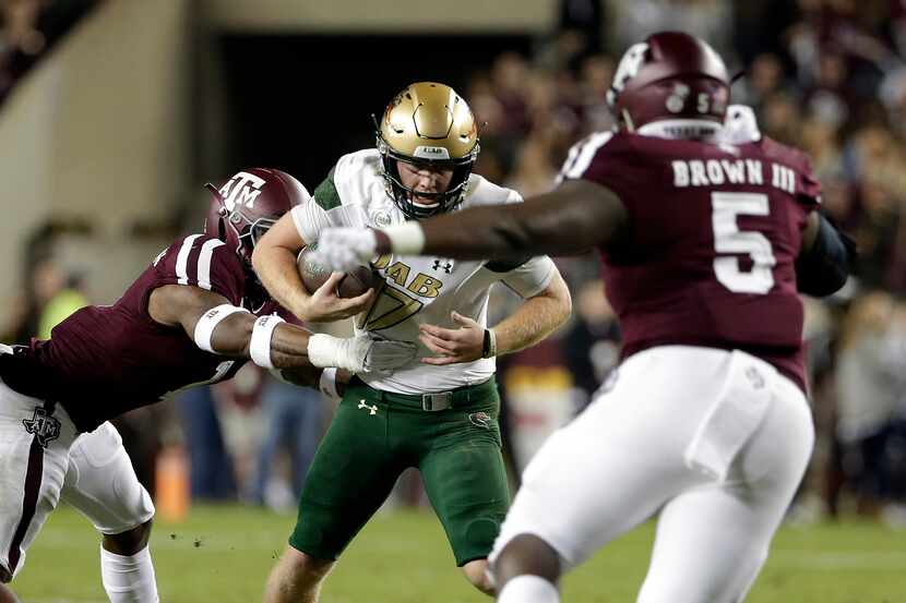 FILE - UAB quarterback Tyler Johnston III (17) is caught on a keeper play between Texas A&M...