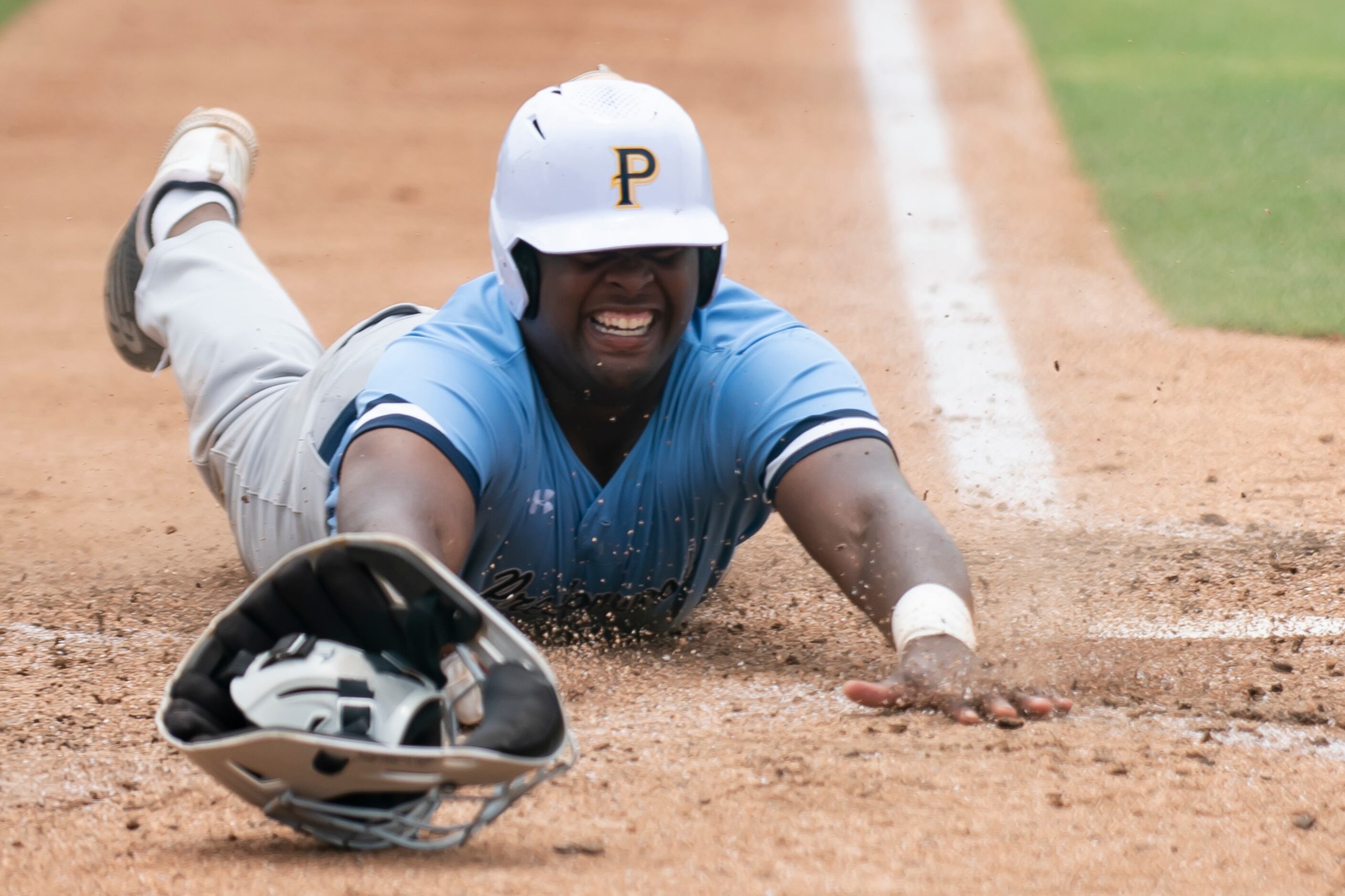 Prestonwood senior Trent Shaw (23) smiles as he slides into home plate to score a run during...