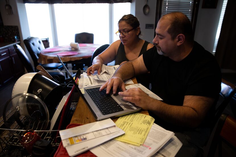 Jesús and Claudia Fierro of Yuma, Ariz., review their high medical bills. They report paying...