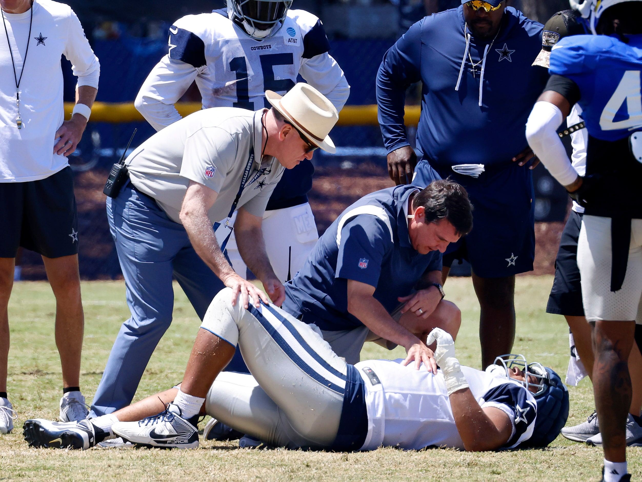 Dallas Cowboys doctor Daniel E. Cooper (left) and head trainer Jim Maurer check on offensive...