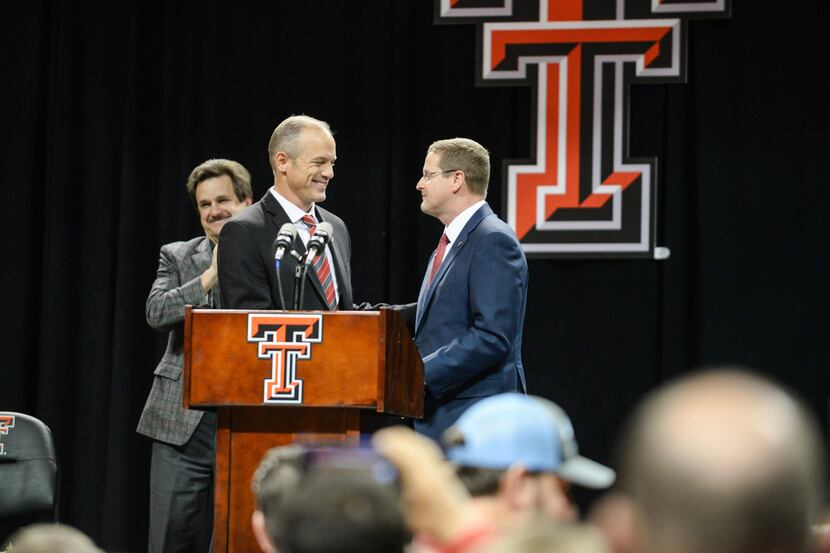 Texas Tech athletics director Kirby Hocutt, right, shakes hands with new head football coach...