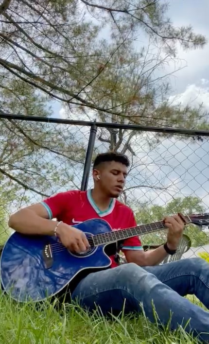 Oscar plays his guitar at his family's home in Indianapolis.