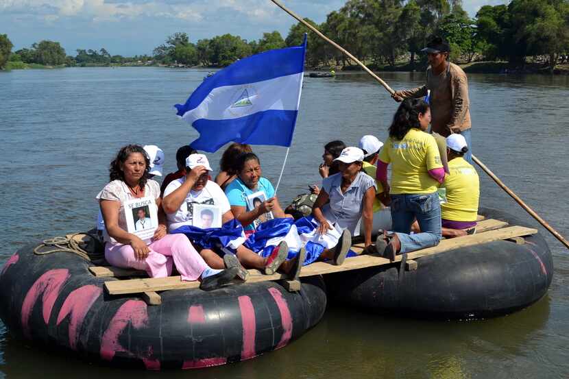 Una balsa con inmigrantes centroamericanos se acerca a la frontera con México, en el estado...