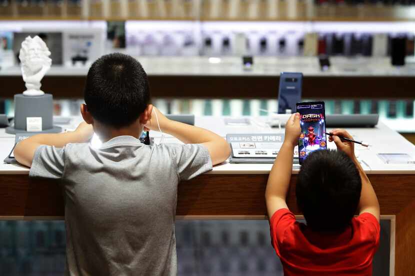  Children experience Samsung Electronics Galaxy Note 8 smartphone at its shop in Seoul,...