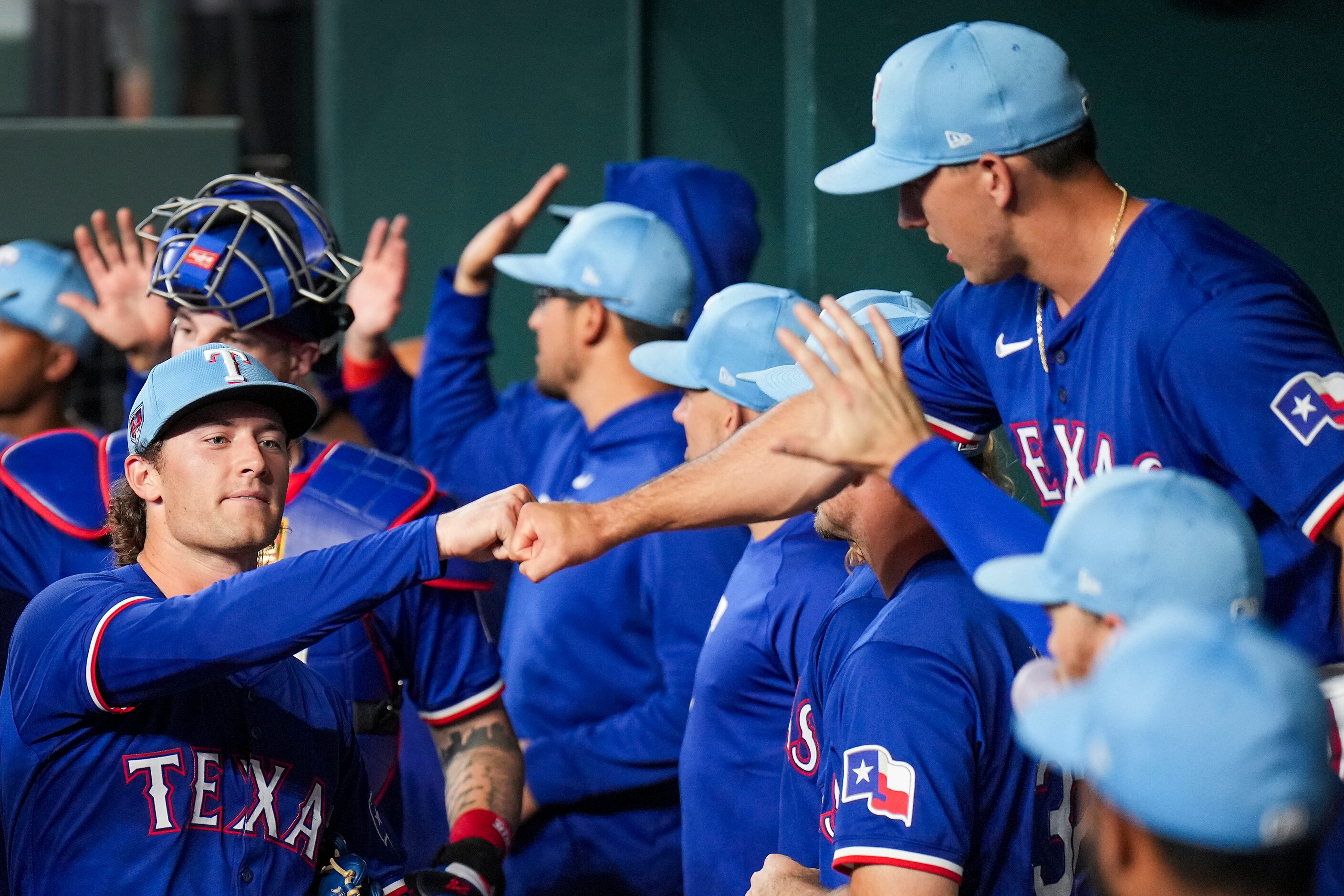 Texas Rangers pitcher Jake Latz (facing)  fist bumps outfielder Wyatt Langford before an...