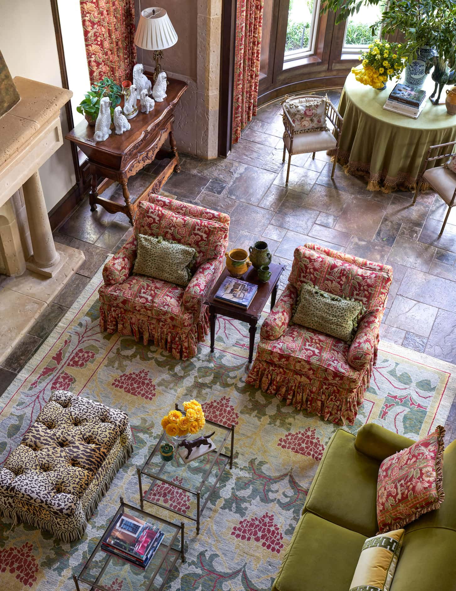 An overhead photograph of a living space shows a seating area with a green sofa, a patterned...