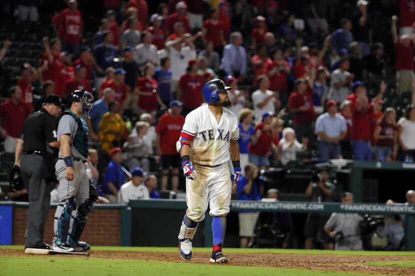 Seattle Mariners catcher Mike Zunino, left, and Texas Rangers' Rougned Odor watch his...