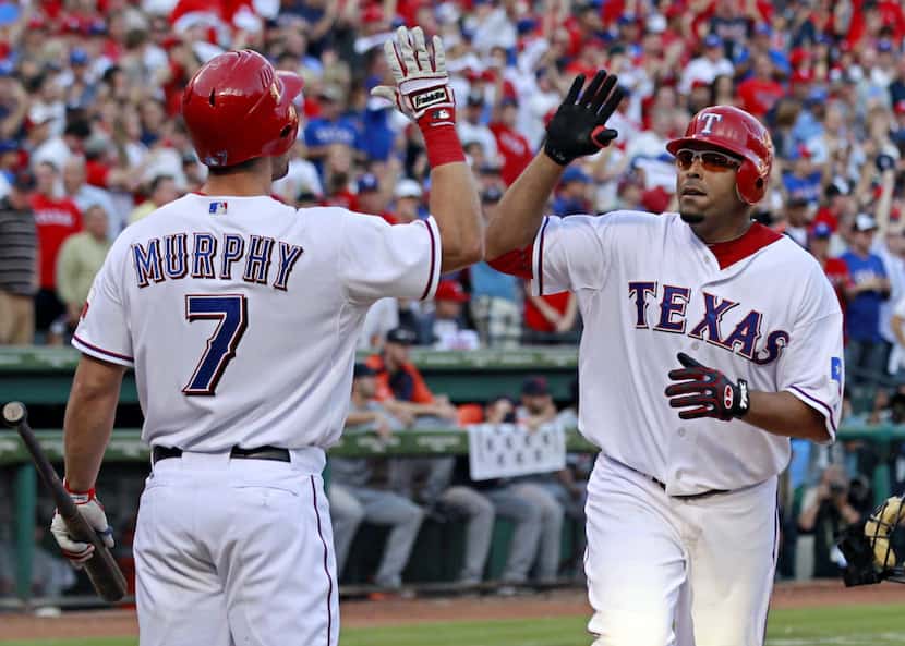 FILE - Texas Rangers left fielder David Murphy (7) congratulates right fielder Nelson Cruz...
