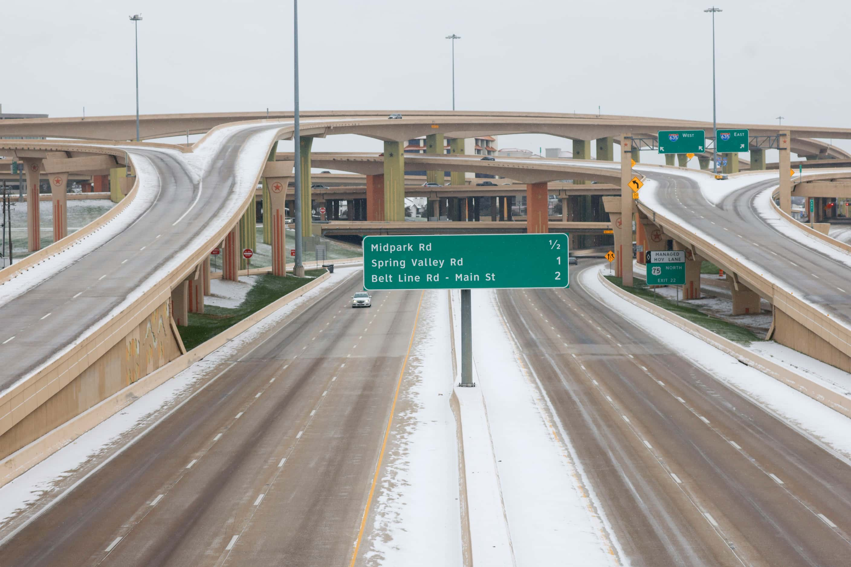 A lone car travels through icy condition on U.S. 75, near High Five Interchange as Monday,...