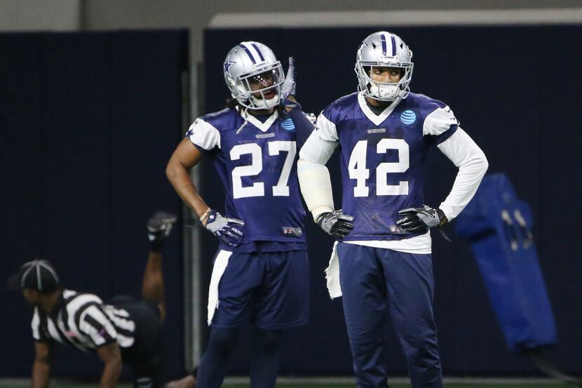Dallas Cowboys strong safety J.J. Wilcox (27) and strong safety Barry Church (42) in between...