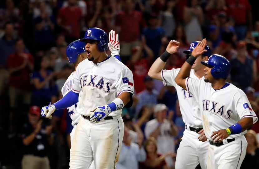 Texas Rangers Carlos Gomez, left, Jared Hoying, center rear, and Elvis Andrus, right, ...