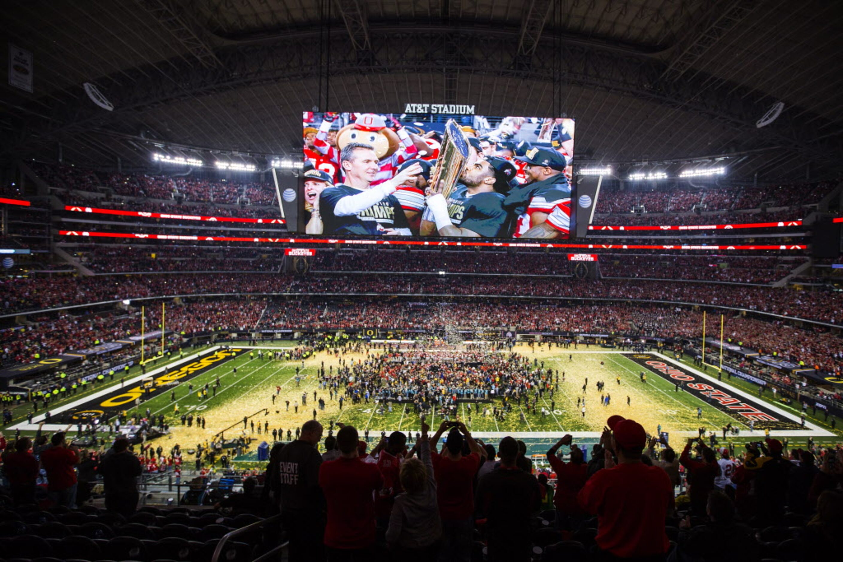 Ohio State running back Ezekiel Elliott is seen on the video screen kissing the trophy as...