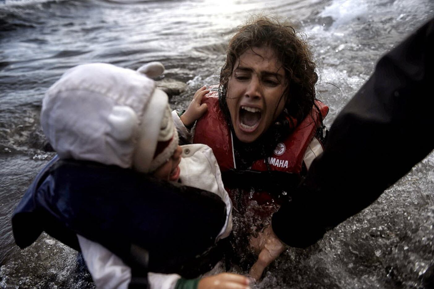 This file photo taken on October 2, 2015 shows a woman falling into the water with her child...