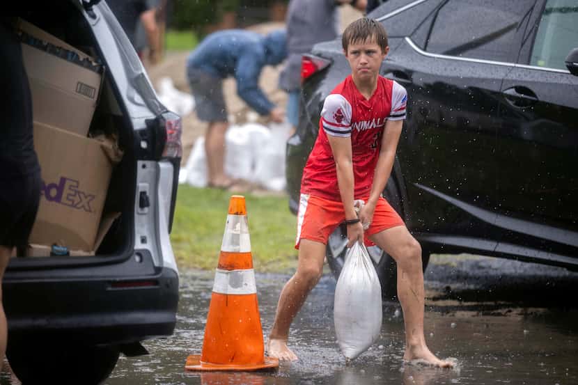 Brantley Schnabel helps his family carry sandbags to their van while preparing for Hurricane...