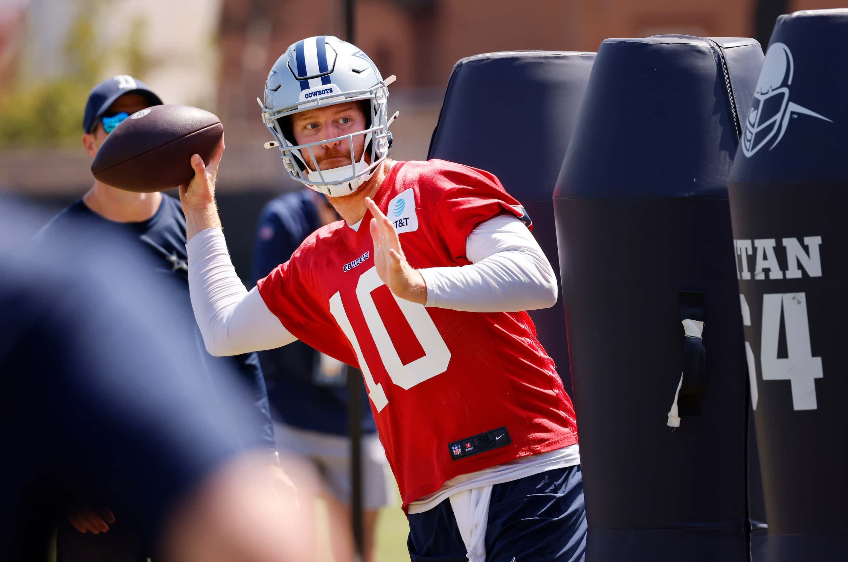 Dallas Cowboys quarterback Cooper Rush (10) zips a pass as he dodges the blocking dummies at...