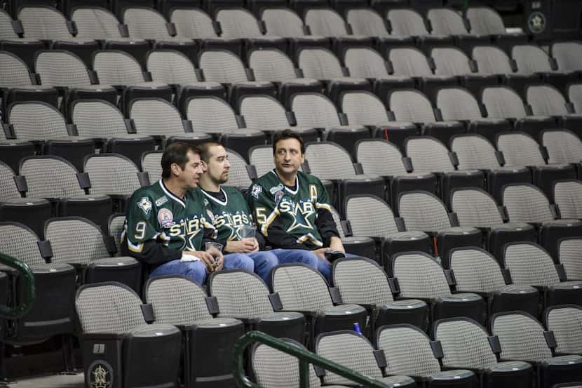 Stars fans from left Russ Sittenauer, Andrew Sittenauer and Jochen Hotz remain in their...
